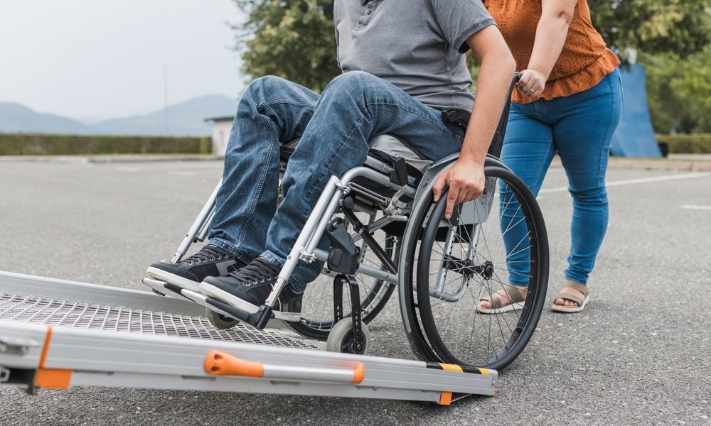 Female,Assistant,Pushing,A,Man,With,Disability,,A,Wheelchair,User
